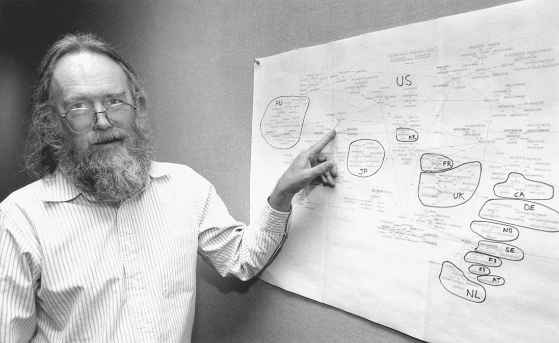 Jon Postel in 1994, with map of Internet top-level domains
